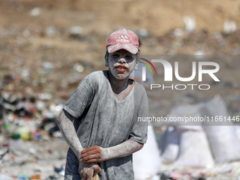 A photo shows Palestinian youths collecting remains of spoiled flour discarded in a makeshift landfill near the tents of displaced people in...