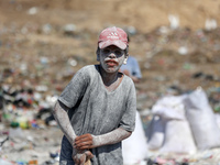 A photo shows Palestinian youths collecting remains of spoiled flour discarded in a makeshift landfill near the tents of displaced people in...