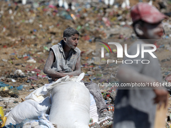 A photo shows Palestinian youths collecting remains of spoiled flour discarded in a makeshift landfill near the tents of displaced people in...