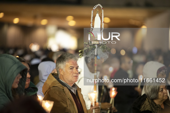 Pilgrims hold candles and pray during the candle procession at the Sanctuary of Fatima, in Fatima, Portugal, on October 12, 2024, on the ann...