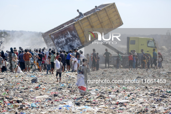 A photo shows Palestinian youths collecting remains of spoiled flour discarded in a makeshift landfill near the tents of displaced people in...