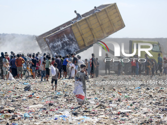 A photo shows Palestinian youths collecting remains of spoiled flour discarded in a makeshift landfill near the tents of displaced people in...