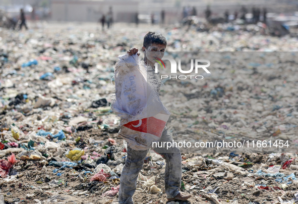 A photo shows Palestinian youths collecting remains of spoiled flour discarded in a makeshift landfill near the tents of displaced people in...