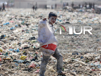 A photo shows Palestinian youths collecting remains of spoiled flour discarded in a makeshift landfill near the tents of displaced people in...