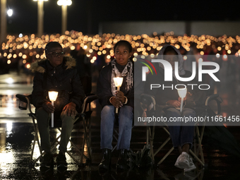 Pilgrims hold candles and pray during the candle procession at the Sanctuary of Fatima, in Fatima, Portugal, on October 12, 2024, on the ann...