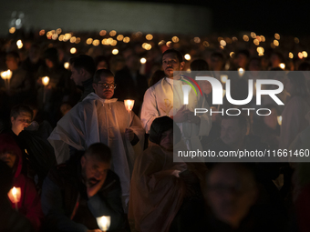 Pilgrims hold candles and pray during the candle procession at the Sanctuary of Fatima, in Fatima, Portugal, on October 12, 2024, on the ann...