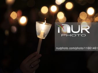 Pilgrims hold candles and pray during the candle procession at the Sanctuary of Fatima, in Fatima, Portugal, on October 12, 2024, on the ann...