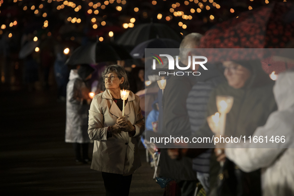 Pilgrims hold candles and pray during the candle procession at the Sanctuary of Fatima, in Fatima, Portugal, on October 12, 2024, on the ann...