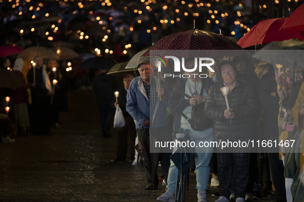 Pilgrims hold candles and pray during the candle procession at the Sanctuary of Fatima, in Fatima, Portugal, on October 12, 2024, on the ann...