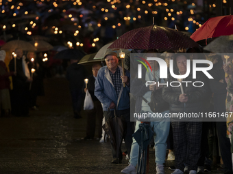 Pilgrims hold candles and pray during the candle procession at the Sanctuary of Fatima, in Fatima, Portugal, on October 12, 2024, on the ann...