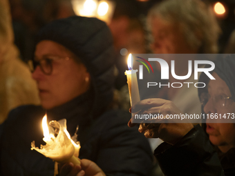 Pilgrims hold candles and pray during the candle procession at the Sanctuary of Fatima, in Fatima, Portugal, on October 12, 2024, on the ann...