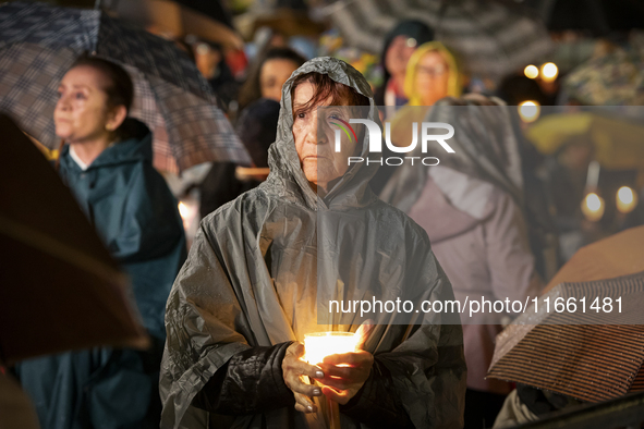 Pilgrims hold candles and pray during the candle procession at the Sanctuary of Fatima, in Fatima, Portugal, on October 12, 2024, on the ann...