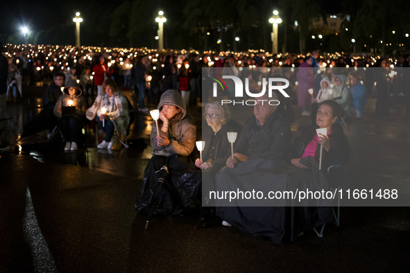 Pilgrims hold candles and pray during the candle procession at the Sanctuary of Fatima, in Fatima, Portugal, on October 12, 2024, on the ann...