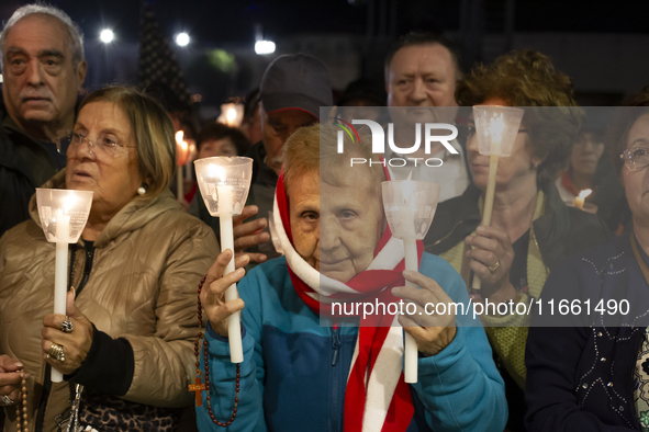 Pilgrims hold candles and pray during the candle procession at the Sanctuary of Fatima, in Fatima, Portugal, on October 12, 2024, on the ann...