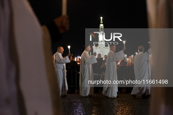 Pilgrims hold candles and pray during the candle procession at the Sanctuary of Fatima, in Fatima, Portugal, on October 12, 2024, on the ann...