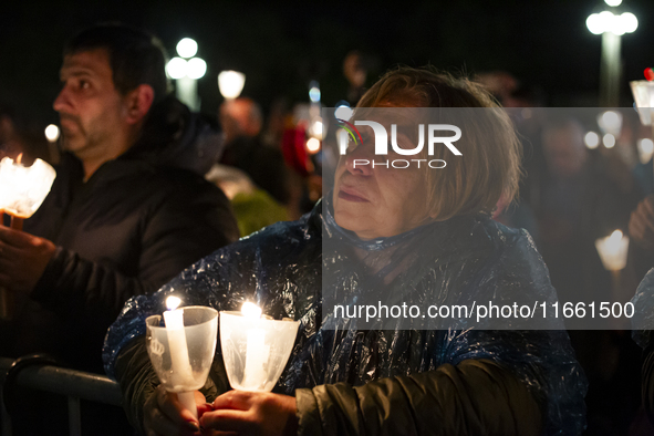 Pilgrims hold candles and pray during the candle procession at the Sanctuary of Fatima, in Fatima, Portugal, on October 12, 2024, on the ann...