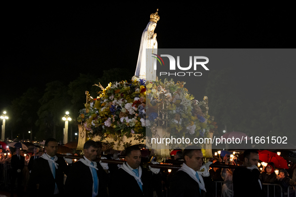 Pilgrims hold candles and pray during the candle procession at the Sanctuary of Fatima, in Fatima, Portugal, on October 12, 2024, on the ann...