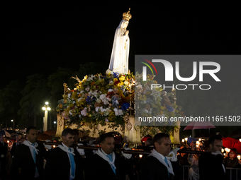 Pilgrims hold candles and pray during the candle procession at the Sanctuary of Fatima, in Fatima, Portugal, on October 12, 2024, on the ann...