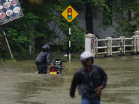 A man pushes a motorcycle on the flooded road in Kelaniya, Sri Lanka, on October 13, 2024. The adverse weather affects approximately 76,218...