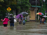 People walk on the flooded road in Kelaniya, Sri Lanka, on October 13, 2024. The adverse weather affects approximately 76,218 people from 18...