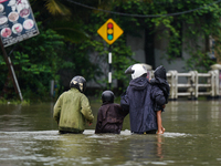 People walk on the flooded road in Kelaniya, Sri Lanka, on October 13, 2024. The adverse weather affects approximately 76,218 people from 18...