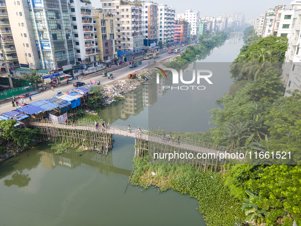 An aerial view shows hundreds of people in Dhaka, Bangladesh, using the makeshift bamboo bridge over the canal at Banasree in the capital ci...