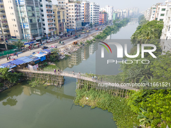 An aerial view shows hundreds of people in Dhaka, Bangladesh, using the makeshift bamboo bridge over the canal at Banasree in the capital ci...