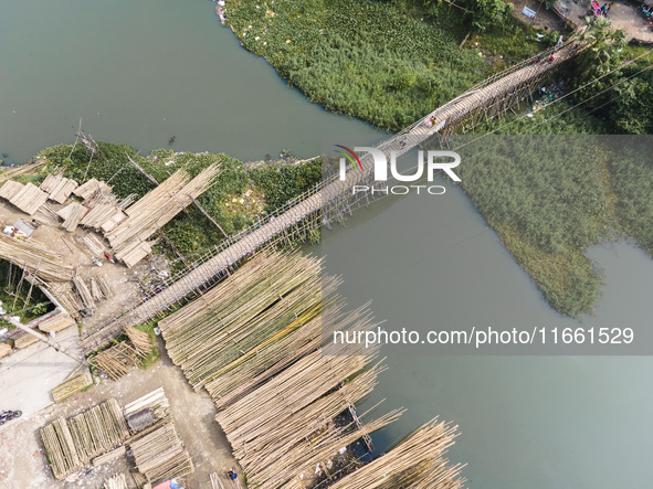 An aerial view shows hundreds of people in Dhaka, Bangladesh, using the makeshift bamboo bridge over the canal at Banasree in the capital ci...