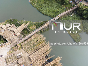 An aerial view shows hundreds of people in Dhaka, Bangladesh, using the makeshift bamboo bridge over the canal at Banasree in the capital ci...