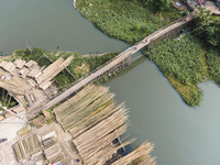 An aerial view shows hundreds of people in Dhaka, Bangladesh, using the makeshift bamboo bridge over the canal at Banasree in the capital ci...