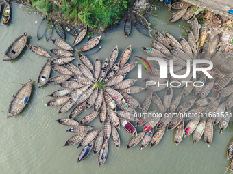 An aerial view shows wooden passenger boats along the Buriganga River in Keraniganj, Dhaka, Bangladesh, on October 13, 2024. The boats, deco...