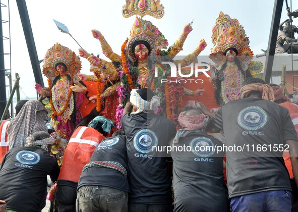 An idol of the Hindu goddess Durga is taken for immersion in the river Brahmaputra on the last day of the Durga Puja festival in Guwahati, I...