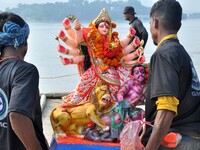 An idol of the Hindu goddess Durga is taken for immersion in the river Brahmaputra on the last day of the Durga Puja festival in Guwahati, I...