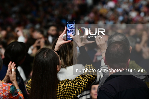 Spectators use telephones to light shows and attend a trumpet concert at the opening night of the light festival in Lyon, France, on October...