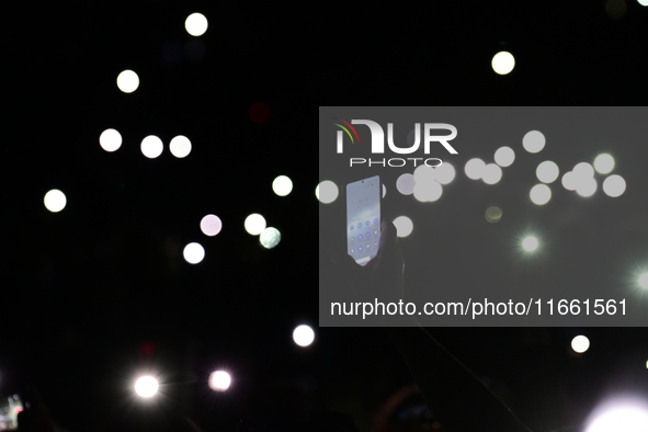 Spectators use telephones to light shows and attend a trumpet concert at the opening night of the light festival in Lyon, France, on October...