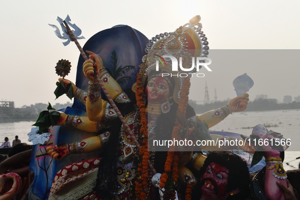 Hindu devotees immerse a clay idol of the Hindu goddess Durga in the Buriganga River on the final day of the Durga Puja festival in Dhaka, B...