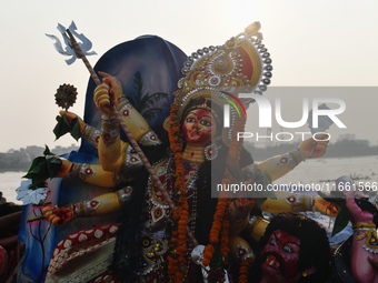 Hindu devotees immerse a clay idol of the Hindu goddess Durga in the Buriganga River on the final day of the Durga Puja festival in Dhaka, B...