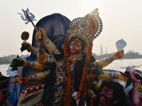 Hindu devotees immerse a clay idol of the Hindu goddess Durga in the Buriganga River on the final day of the Durga Puja festival in Dhaka, B...