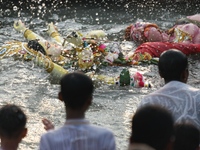 Hindu devotees immerse a clay idol of the Hindu goddess Durga in the Buriganga River on the final day of the Durga Puja festival in Dhaka, B...