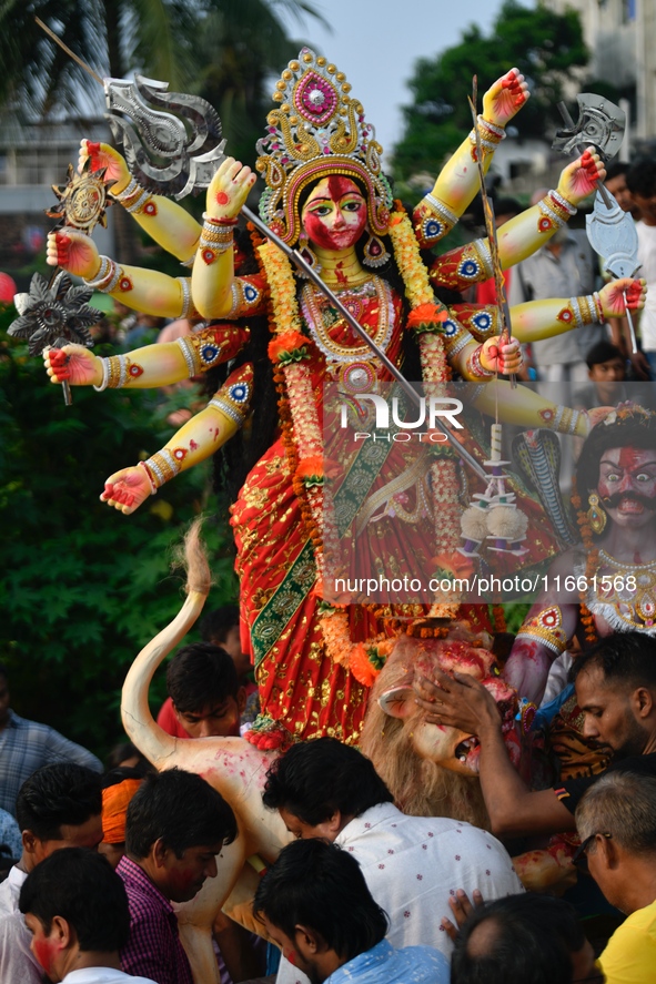 Hindu devotees immerse a clay idol of the Hindu goddess Durga in the Buriganga River on the final day of the Durga Puja festival in Dhaka, B...