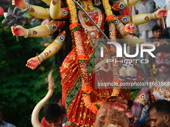 Hindu devotees immerse a clay idol of the Hindu goddess Durga in the Buriganga River on the final day of the Durga Puja festival in Dhaka, B...