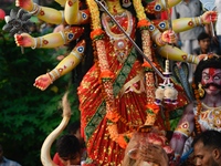 Hindu devotees immerse a clay idol of the Hindu goddess Durga in the Buriganga River on the final day of the Durga Puja festival in Dhaka, B...