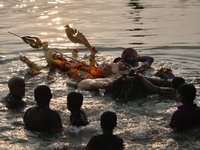 Hindu devotees immerse a clay idol of the Hindu goddess Durga in the Buriganga River on the final day of the Durga Puja festival in Dhaka, B...