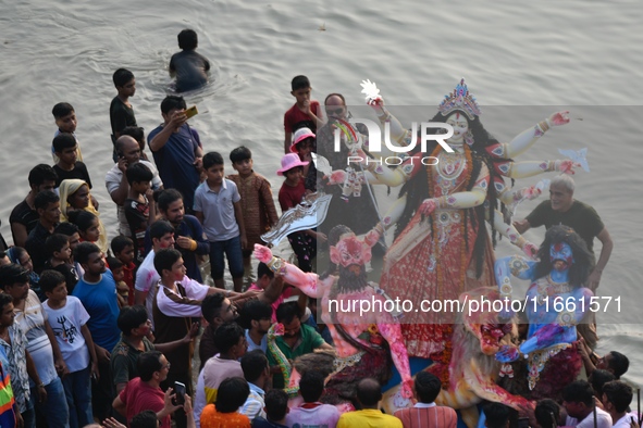 Hindu devotees immerse a clay idol of the Hindu goddess Durga in the Buriganga River on the final day of the Durga Puja festival in Dhaka, B...