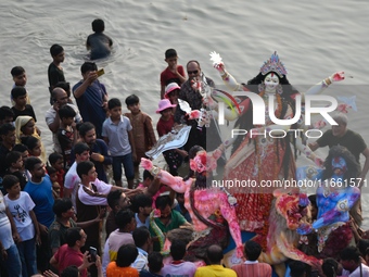 Hindu devotees immerse a clay idol of the Hindu goddess Durga in the Buriganga River on the final day of the Durga Puja festival in Dhaka, B...