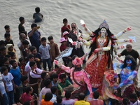 Hindu devotees immerse a clay idol of the Hindu goddess Durga in the Buriganga River on the final day of the Durga Puja festival in Dhaka, B...