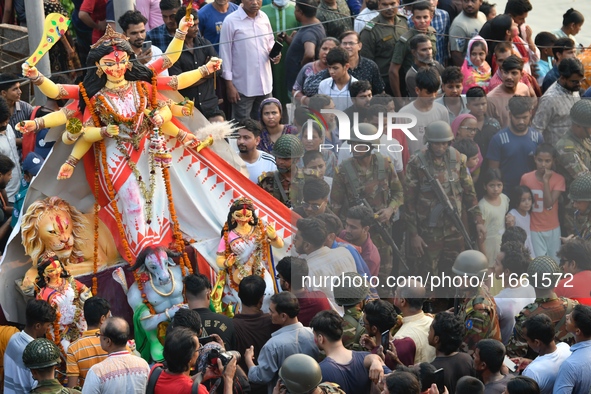 Hindu devotees immerse a clay idol of the Hindu goddess Durga in the Buriganga River on the final day of the Durga Puja festival in Dhaka, B...