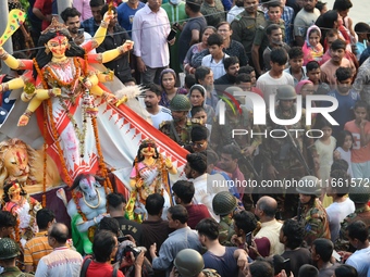 Hindu devotees immerse a clay idol of the Hindu goddess Durga in the Buriganga River on the final day of the Durga Puja festival in Dhaka, B...