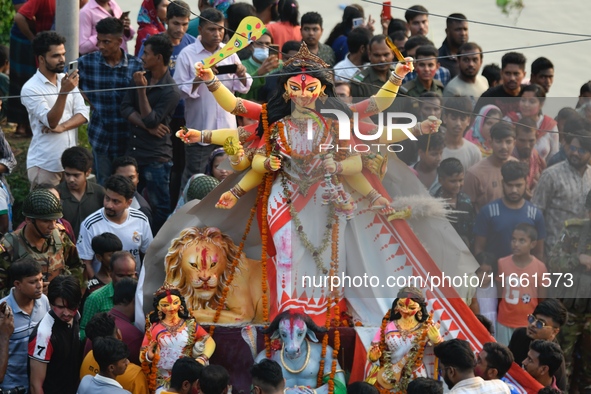 Hindu devotees immerse a clay idol of the Hindu goddess Durga in the Buriganga River on the final day of the Durga Puja festival in Dhaka, B...