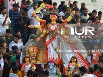 Hindu devotees immerse a clay idol of the Hindu goddess Durga in the Buriganga River on the final day of the Durga Puja festival in Dhaka, B...